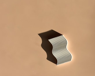 Portrait-style photo of a helix sculpture floating with subtle shadow shifts on a clean white background.