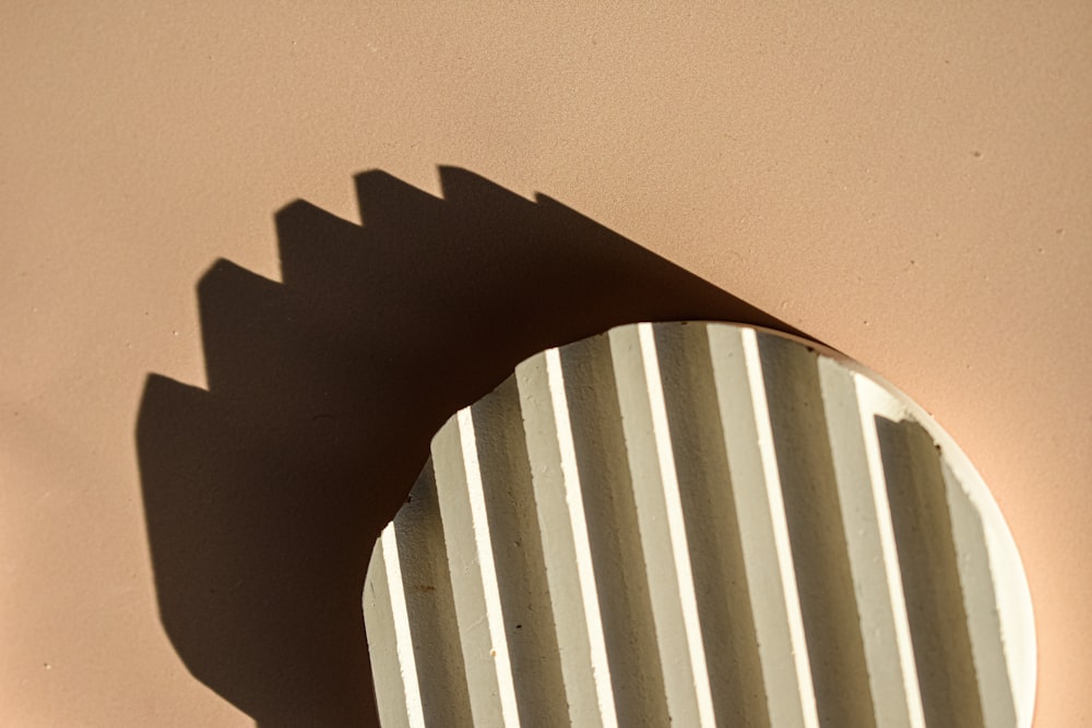 a round mirror on a wall with a shadow on it