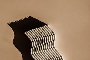 A one-of-a-kind sculptural piece casting deliberate shadows on a textured wall.