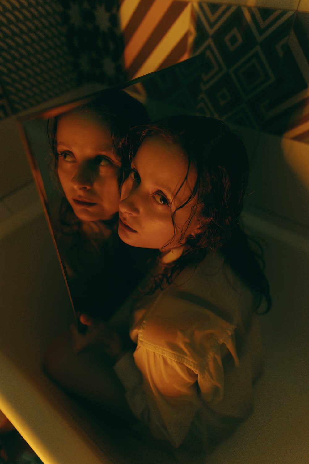 two young girls looking at themselves in a mirror