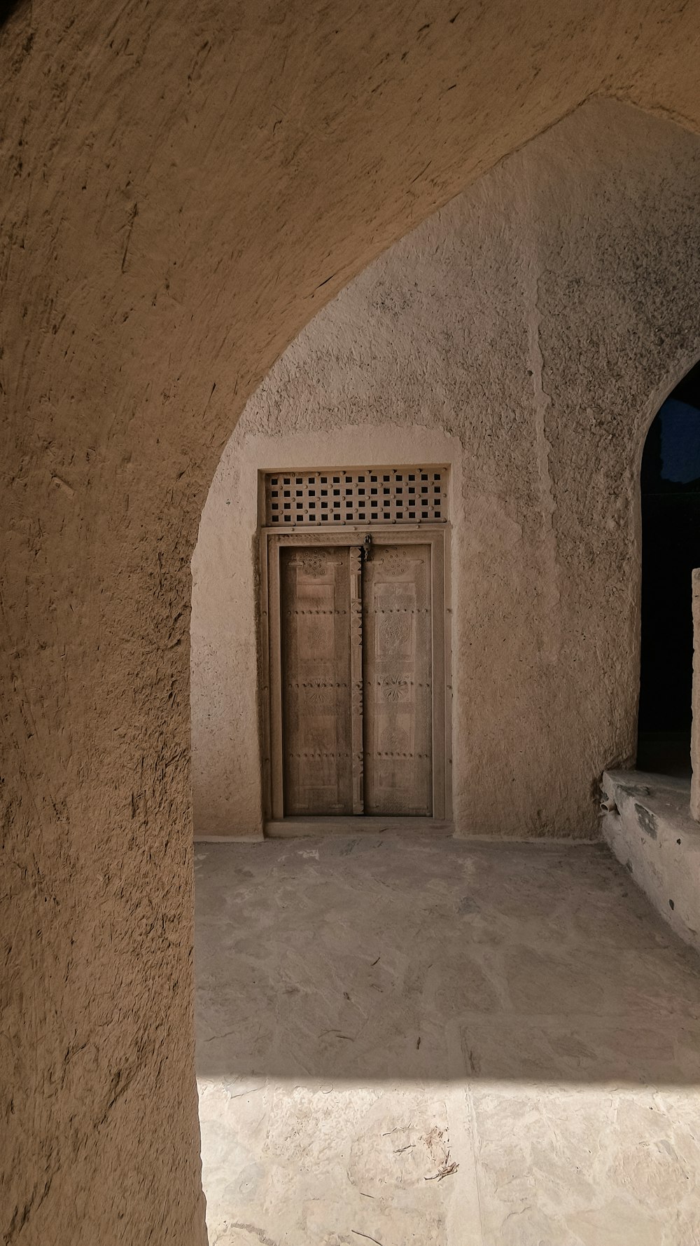 uma porta em um edifício de pedra com uma porta de madeira