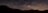 A panoramic view of the Milky Way stretching across a dark, clear night sky.