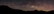 A panoramic view of the Milky Way stretching across a dark, clear night sky.