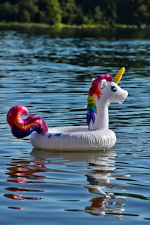 A bright inflatable unicorn pool glowing under the summer sun with kids laughing inside.