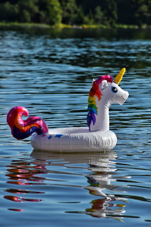A bright inflatable unicorn pool glowing under the summer sun with kids laughing inside.