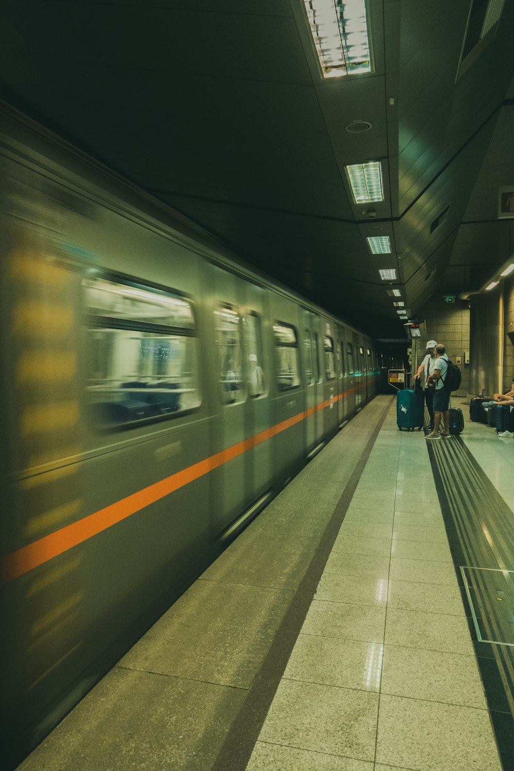 a train traveling through a train station next to a loading platform