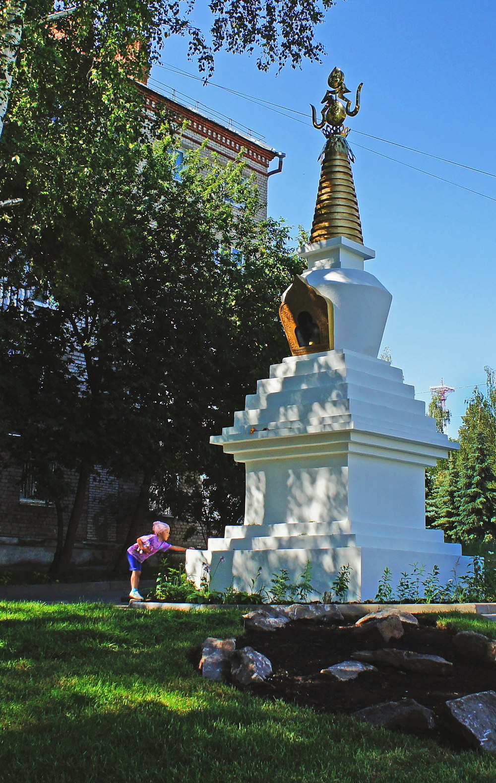 une personne debout devant une grande statue blanche