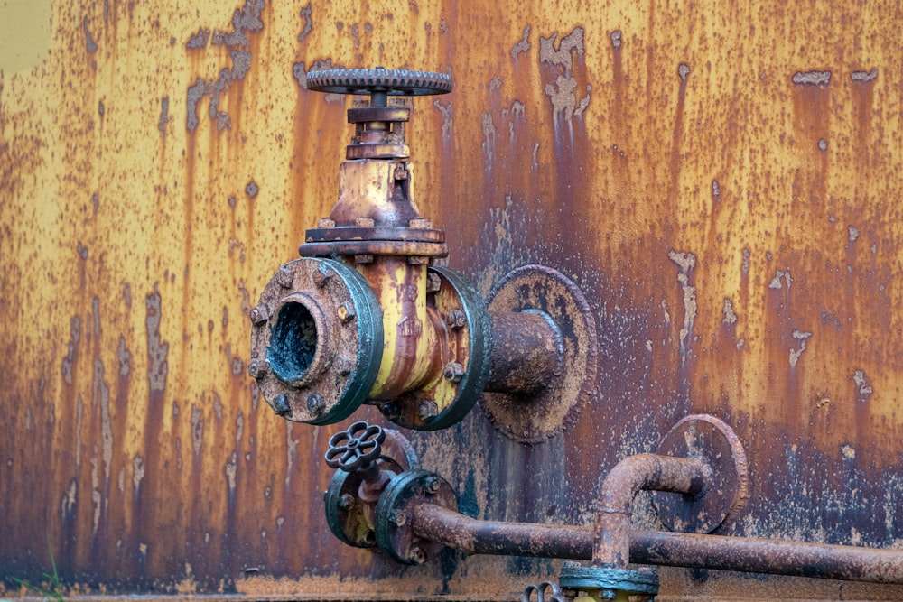 a rusted out fire hydrant next to a rusted wall