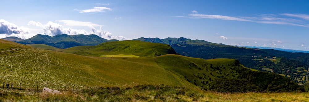 uma vista das montanhas de uma colina gramada