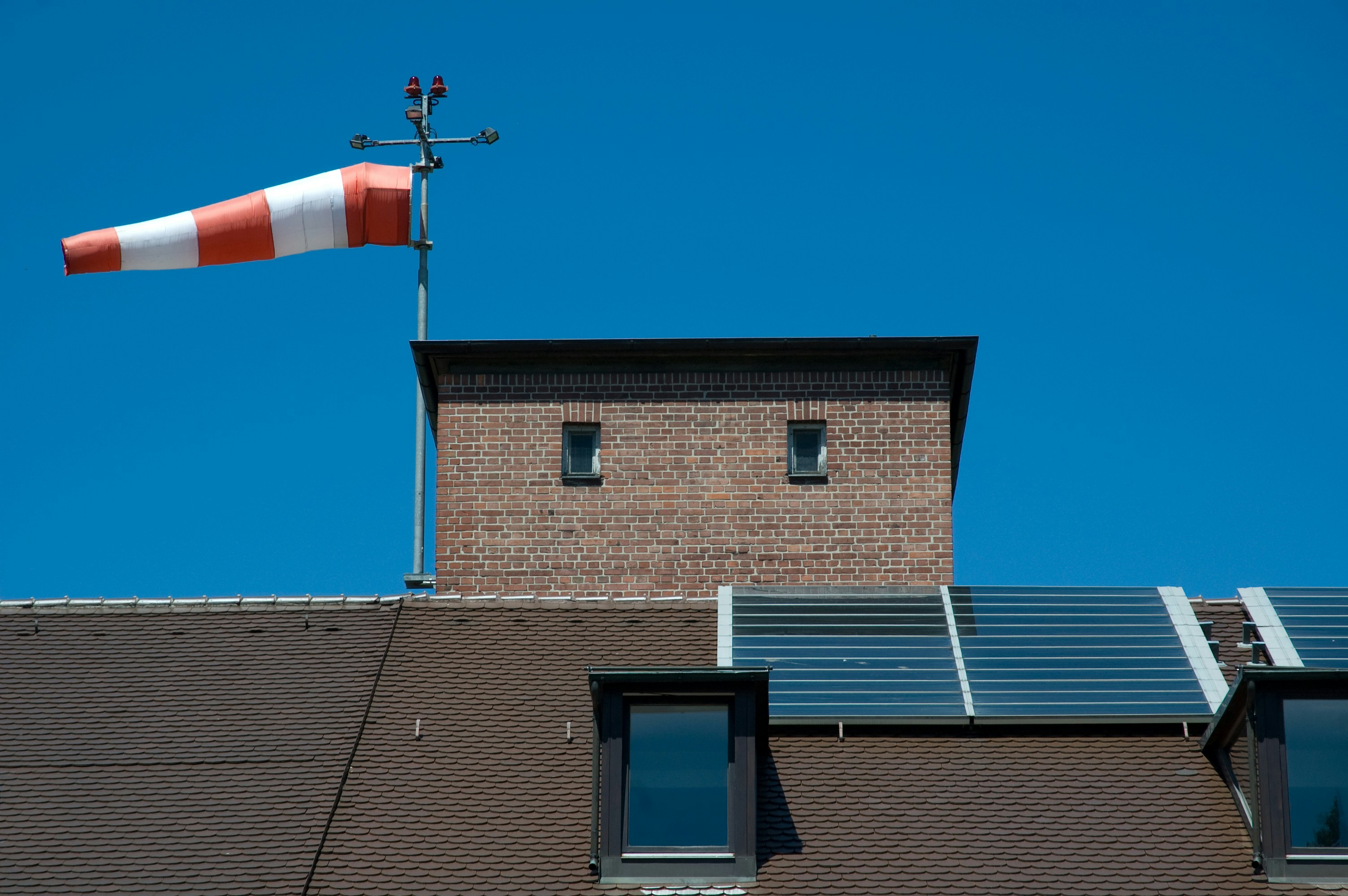 a red and white flag on top of a brick building