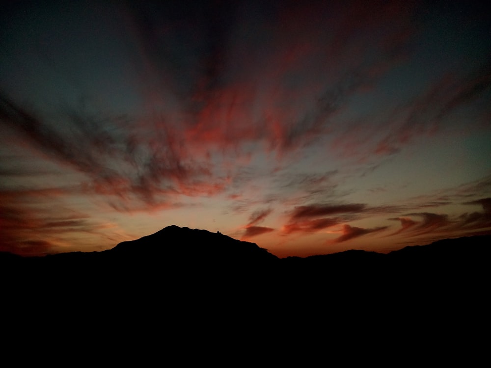 Ein Sonnenuntergang mit einem Berg im Hintergrund
