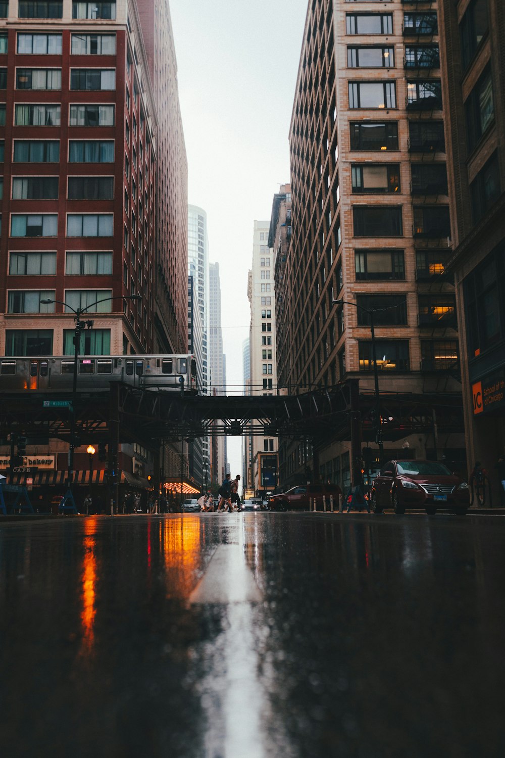 a city street with tall buildings and a bridge