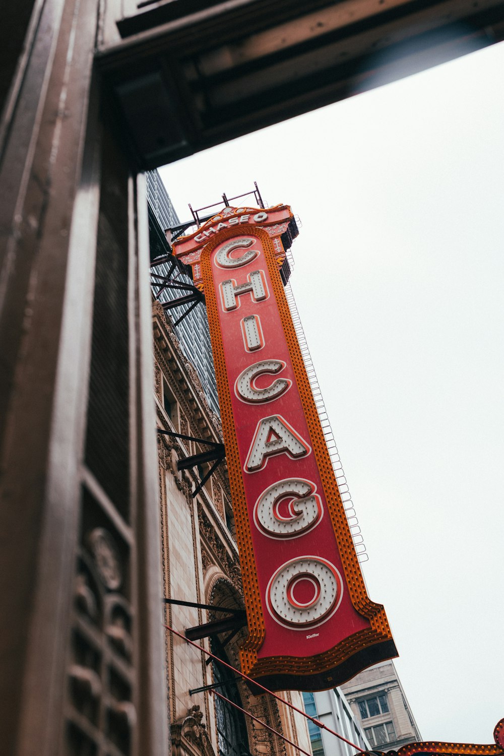 a red sign hanging from the side of a building