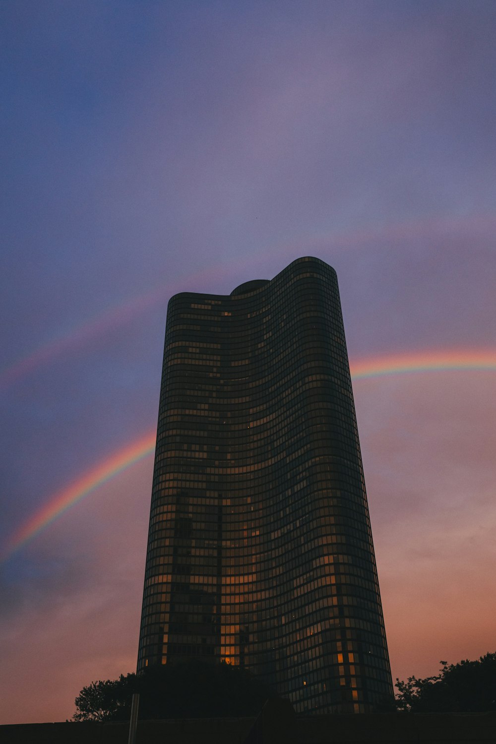 a tall building with a rainbow in the sky