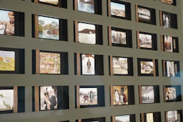 A close-up of hands arranging photographs in a sliding gallery display.