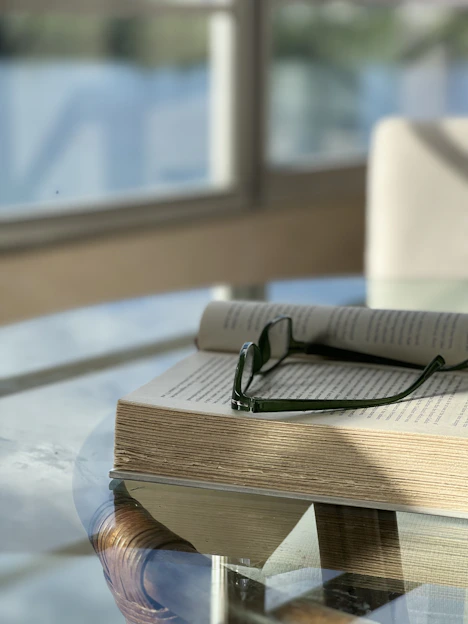 an open book with a pair of glasses on top of it