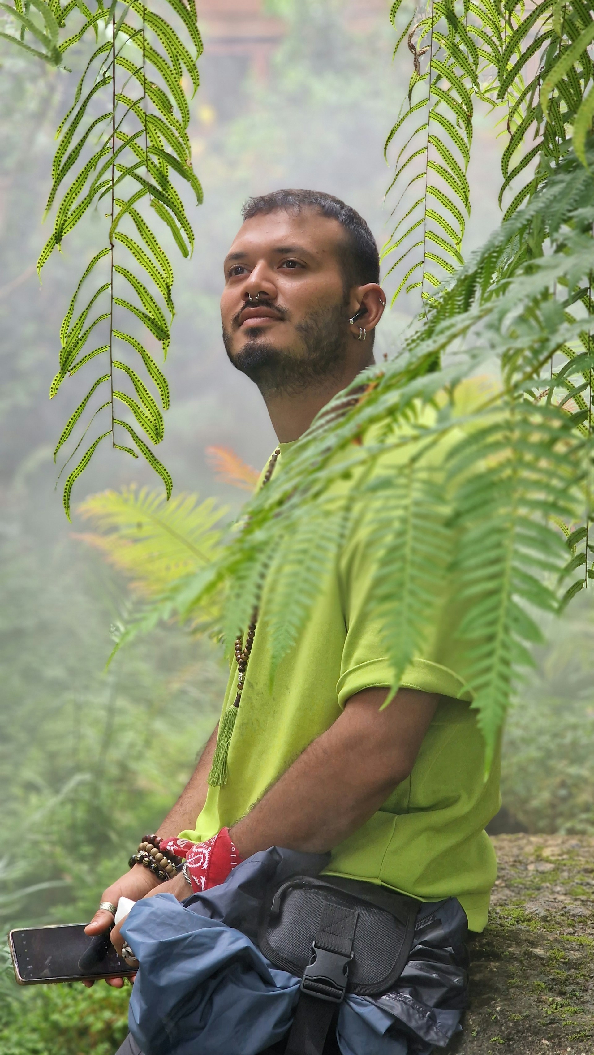 A lifestyle shot of a person sitting peacefully outdoors, wearing the enlightenring while holding a phone, symbolizing the guiding wisdom session.