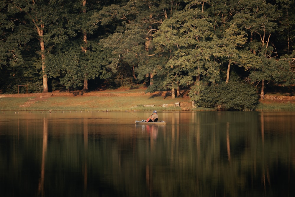 a person in a small boat on a lake