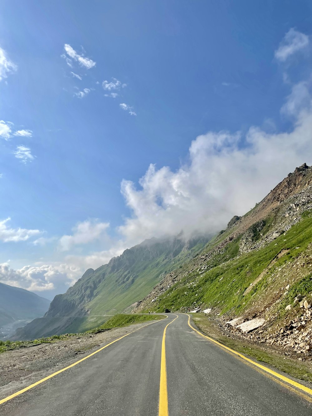 an empty road with a mountain in the background