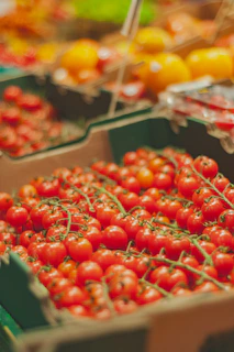 Close-up of ripe tomatoes and cucumbers arranged neatly in a wooden box.