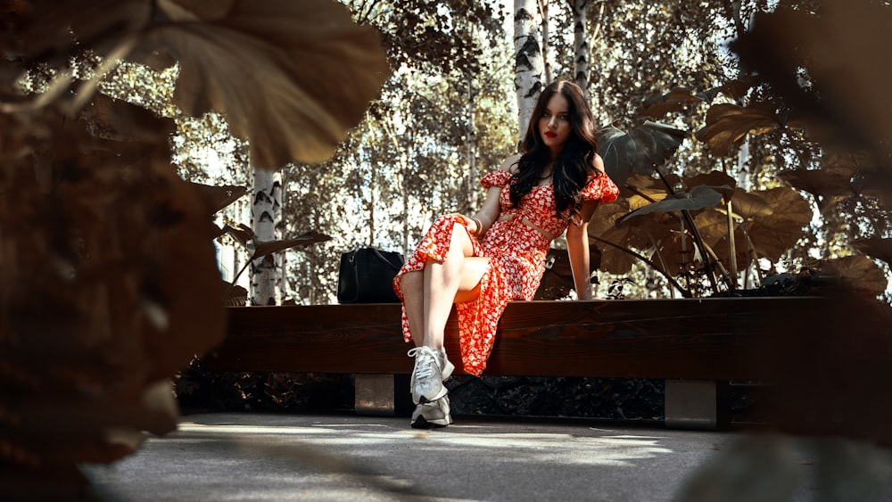 a woman in a red dress sitting on a bench