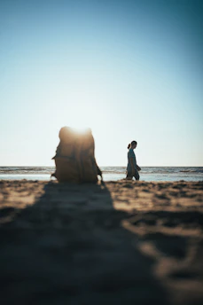 A serene beach sunset with a lone traveler planning their next adventure on a laptop.