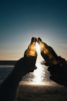 Friends sharing a laugh and water bottles after a sunset run along the beach.