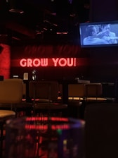 a neon sign that says grow you on a wall which implies a Growth Package