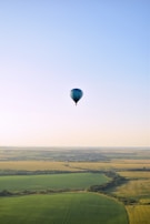A hot air balloon drifting peacefully over rolling hills dotted with wildflowers.