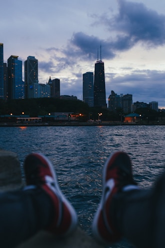 a person's feet on the edge of a body of water