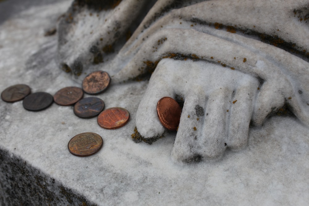 a close up of a statue with a lot of coins