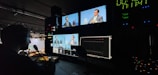Team member analyzing news footage on multiple screens in a dark room.
