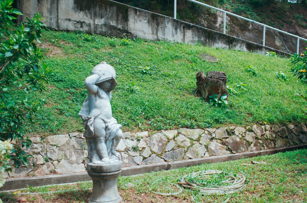 a statue of a boy sitting on top of a fire hydrant