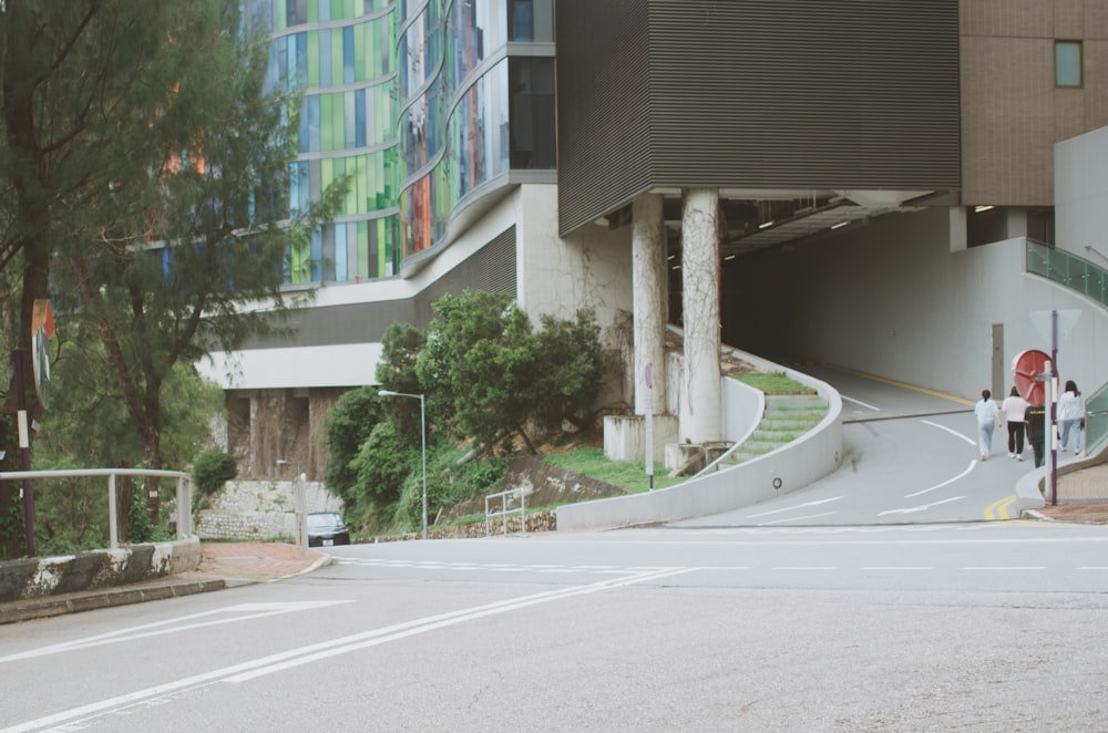 a couple of people walking down a street next to a tall building