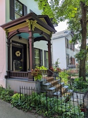 Charming front porch of a rental house surrounded by lush greenery.