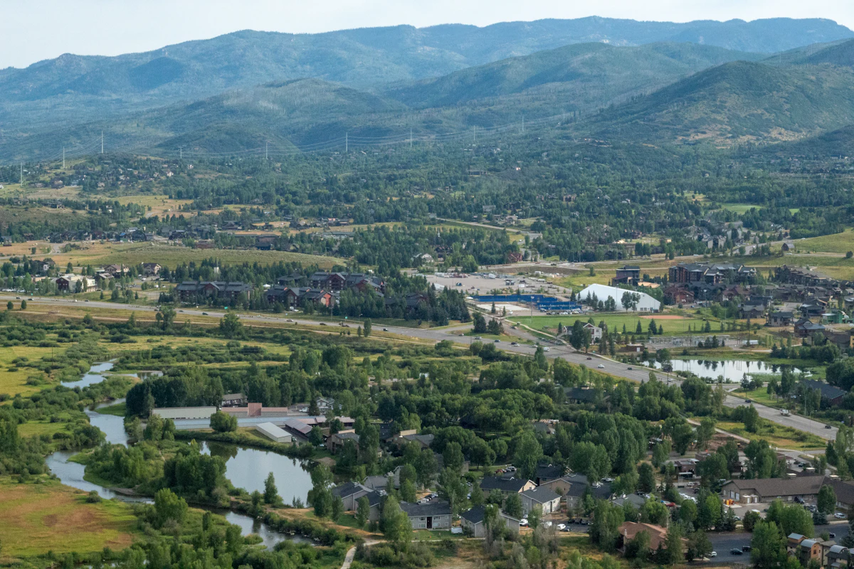 Steamboat Springs from the air, with a river, ponds and green hills behind the town