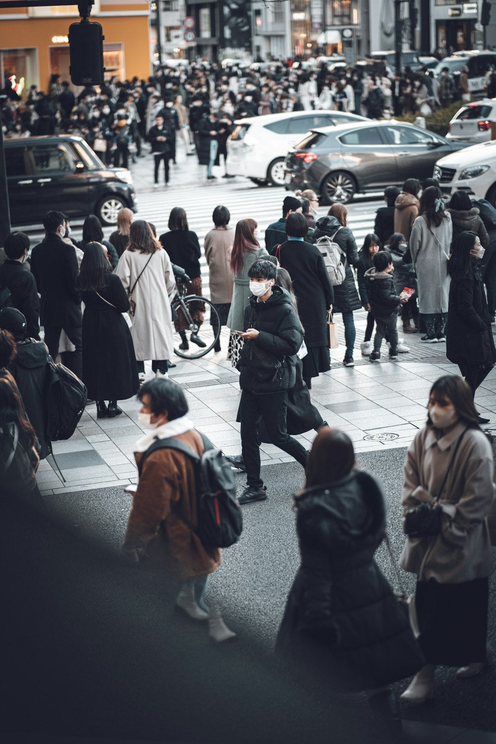 a crowd of people walking down a street next to tall buildings