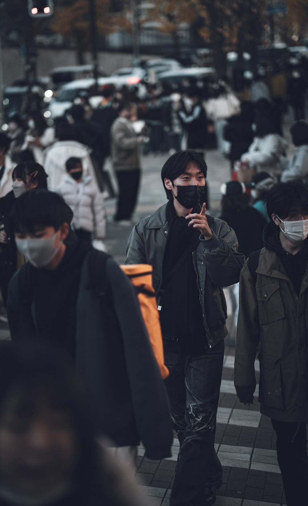 a group of people walking down a street wearing face masks