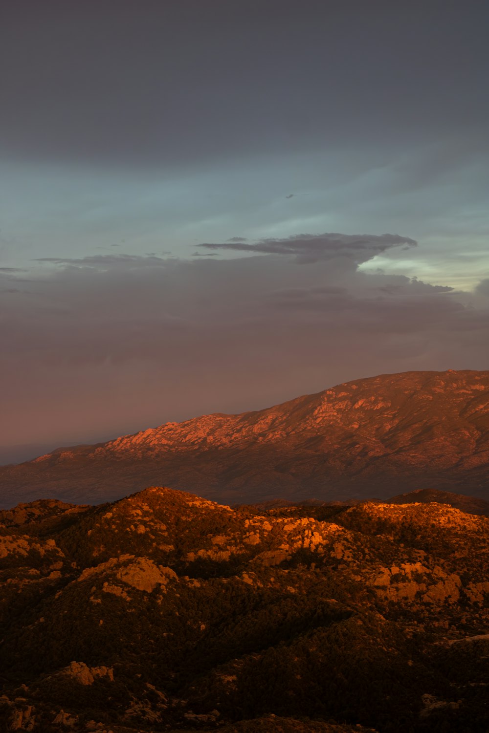 a view of a mountain range with a sunset in the background