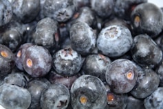 A close-up of fresh, plump wild blueberries on a wooden table.