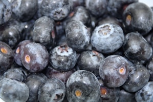 A close-up of fresh, plump wild blueberries on a wooden table.