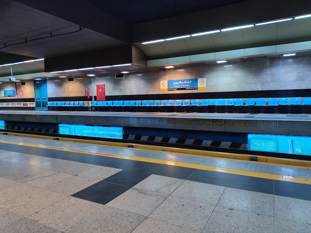 an empty subway station with blue and yellow lights