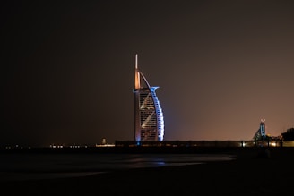 Elegant shot of Burj Al Arab lit up against a dark sky.