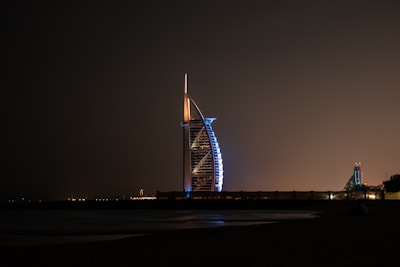 Elegant shot of Burj Al Arab lit up against a dark sky.