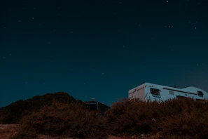 Open rooftop tent of a VW T5 camper under a starry night sky.