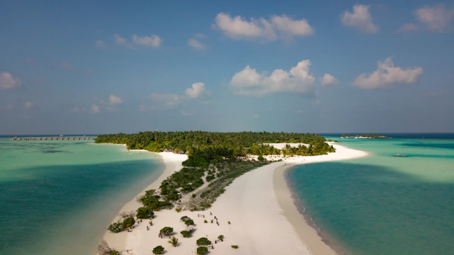 A breathtaking aerial view of a secluded Philippine island surrounded by turquoise waters and lush greenery.