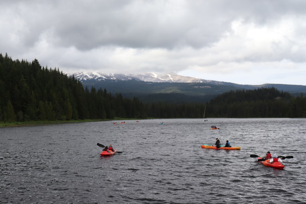 a group of people in kayaks paddling on a lake