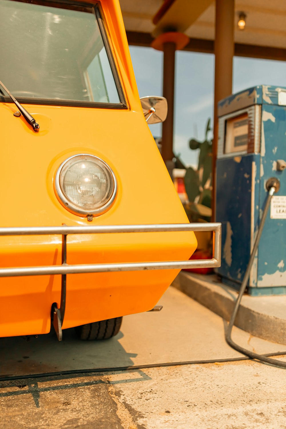 an orange van parked next to a gas pump