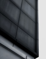 Modern commercial building facade featuring dark grey cladding and clean geometric shapes.