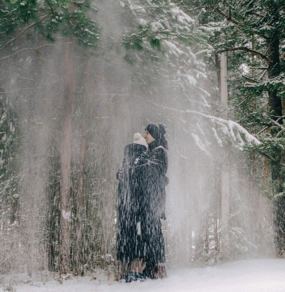 a person standing in the snow in front of trees